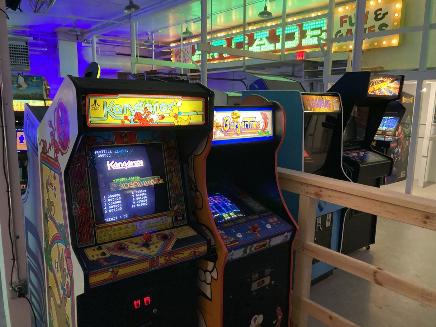 A row of classic arcade cabinets on the Two Bit Game Room floor