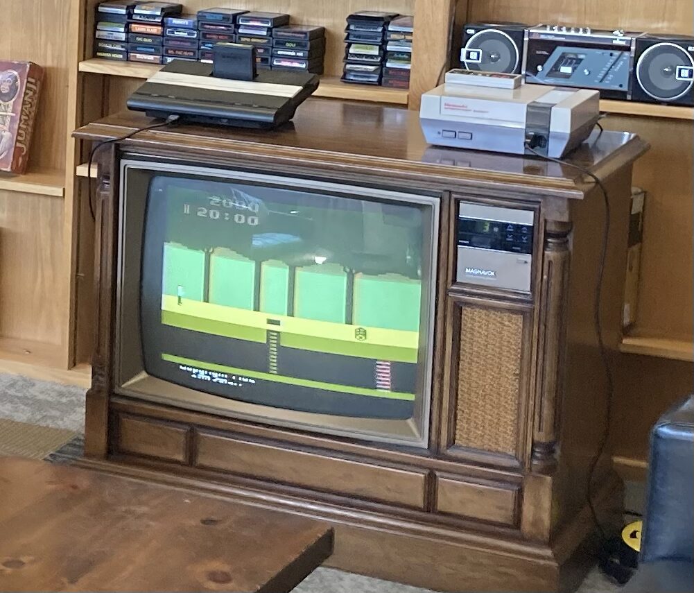 An Atari and an NES on a wood-cabinet console TV
