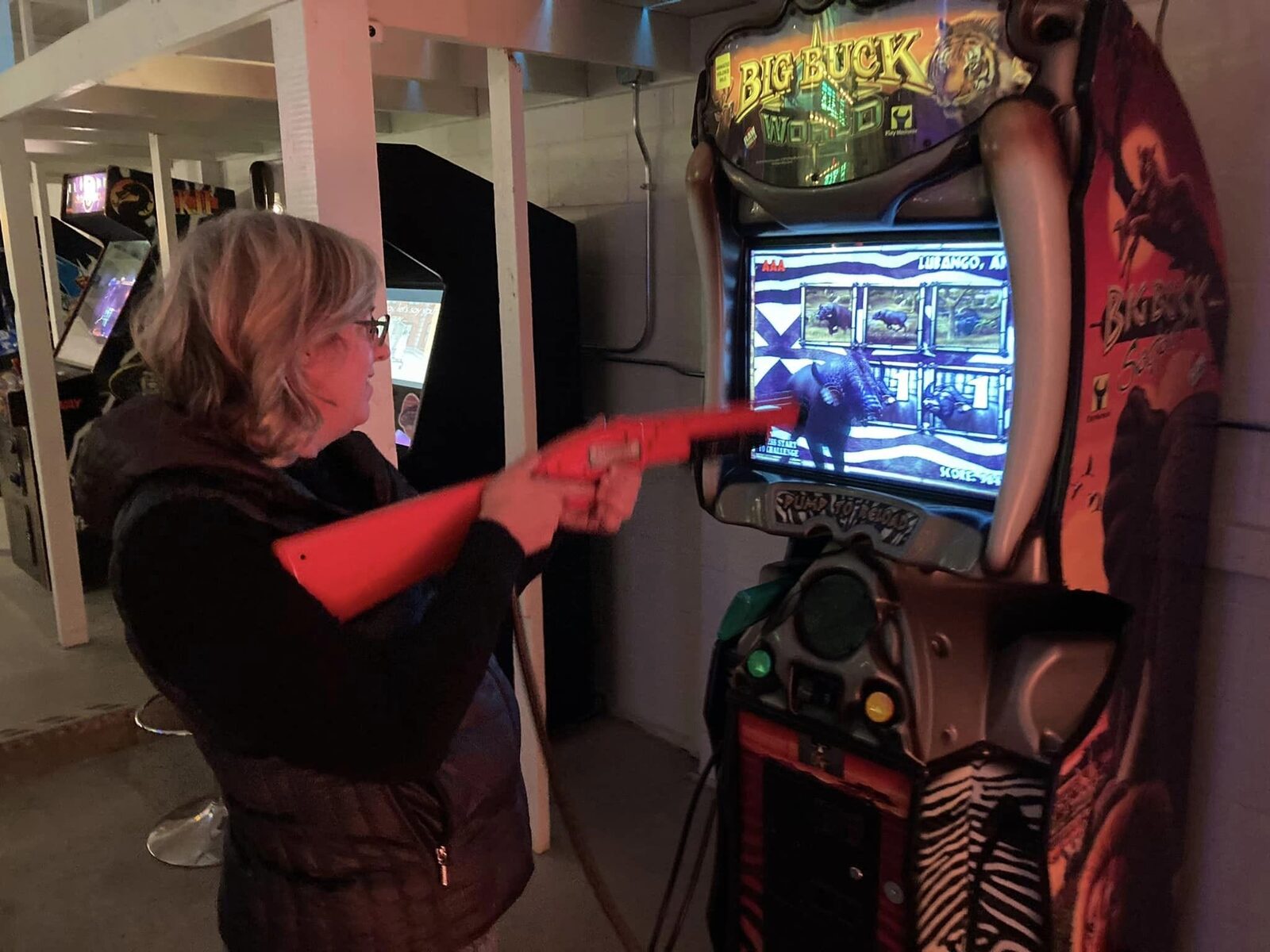 A guest aiming a light gun at an arcade shooter